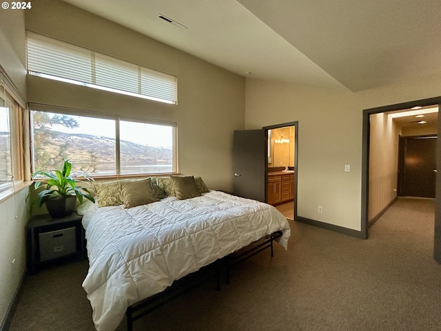 carpeted bedroom with connected bathroom, a mountain view, and lofted ceiling