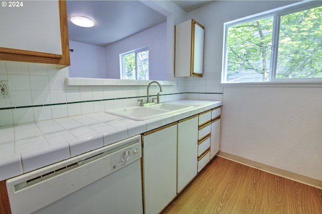 kitchen featuring sink, white cabinetry, tile countertops, white dishwasher, and backsplash