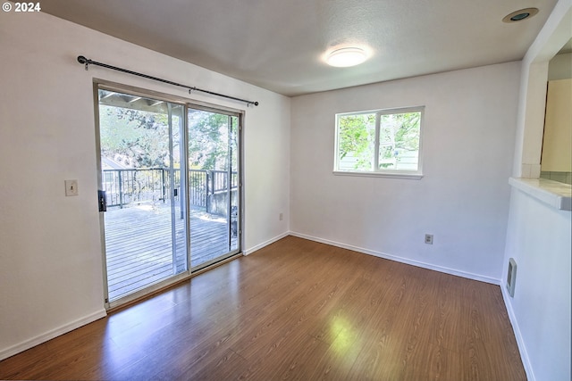 empty room featuring wood-type flooring and plenty of natural light