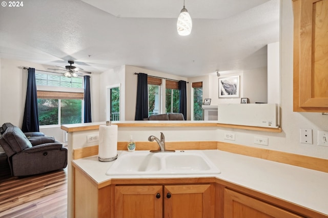 kitchen featuring a textured ceiling, decorative light fixtures, a healthy amount of sunlight, and sink