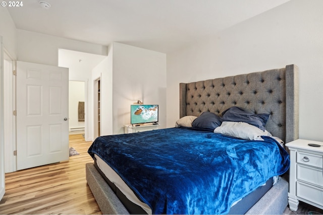 bedroom with baseboard heating and light wood-type flooring