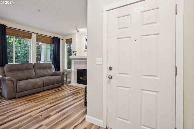 living room featuring a tile fireplace and light hardwood / wood-style floors