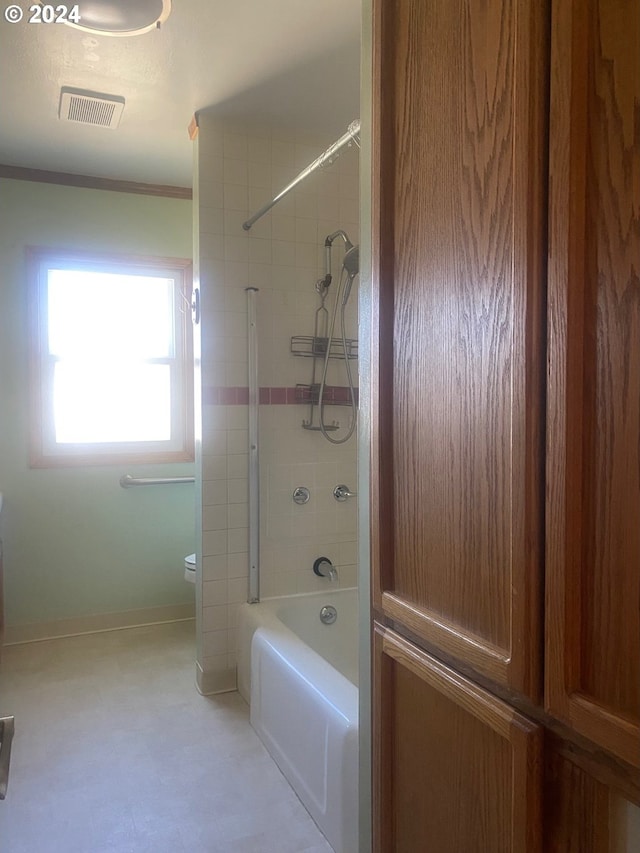 bathroom featuring ornamental molding and tiled shower / bath combo