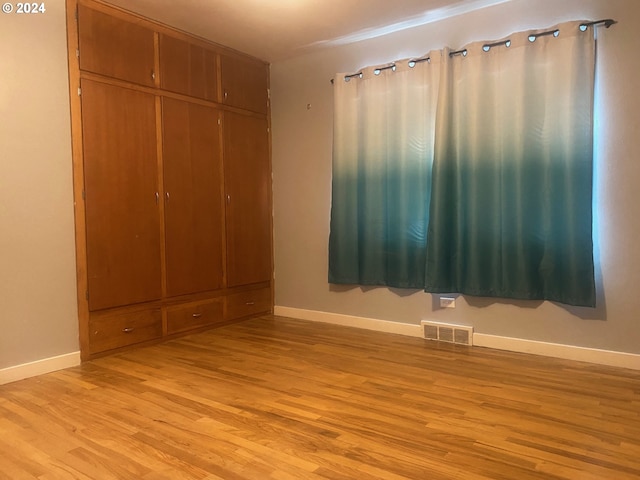 unfurnished bedroom with light hardwood / wood-style floors and a closet