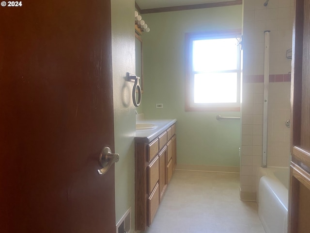 bathroom with vanity, tiled shower / bath, and ornamental molding