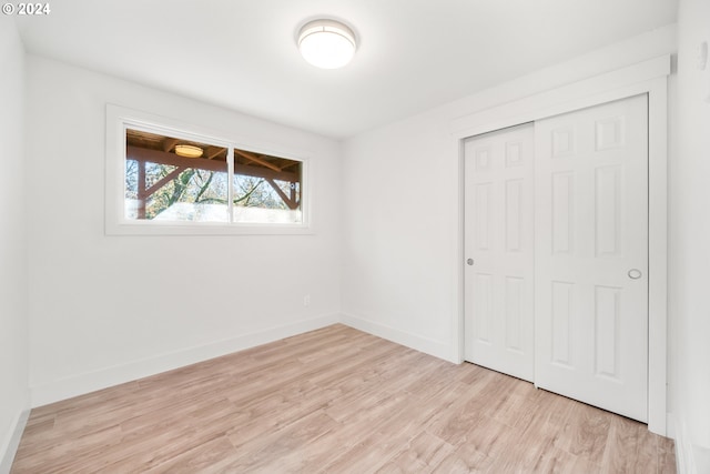 unfurnished bedroom featuring light wood-type flooring and a closet