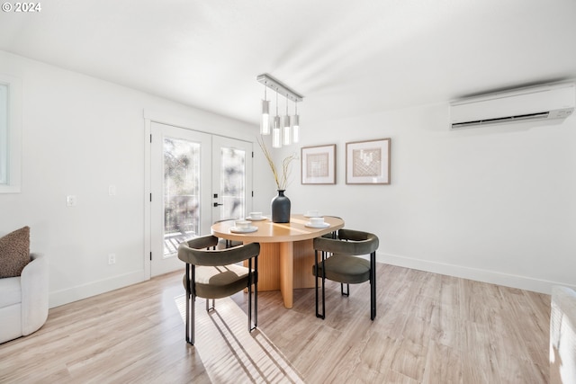 dining area featuring light hardwood / wood-style flooring, french doors, and an AC wall unit