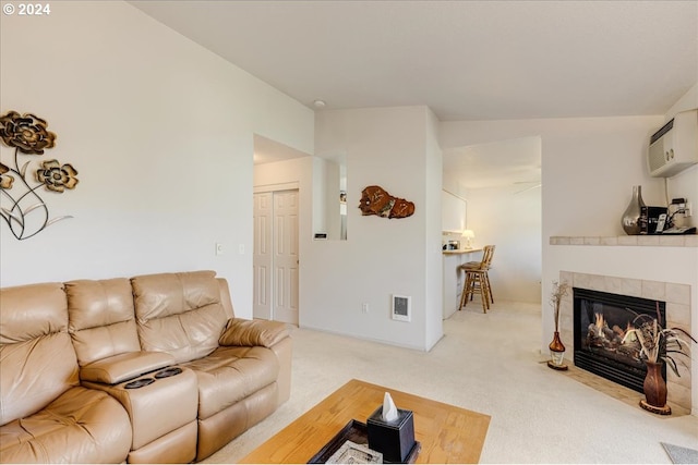 4744 W Powell Blvd Unit K227, Gresham, OR 97030 - living area with a wall unit AC, a tiled fireplace, visible vents, light carpet, and lofted ceiling