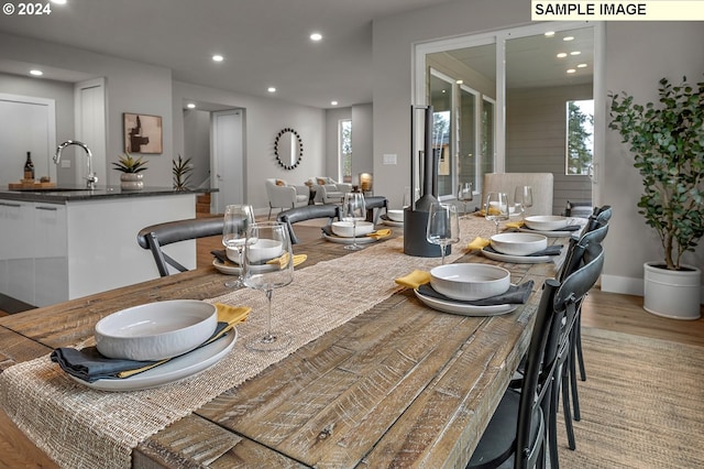 dining area with sink, light hardwood / wood-style floors, and a healthy amount of sunlight