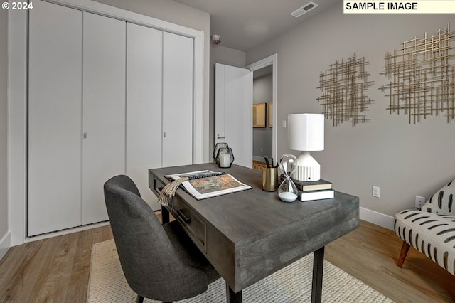 home office with light hardwood / wood-style flooring