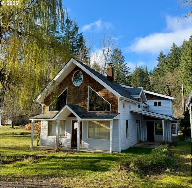 view of front of house with a chimney and a front lawn