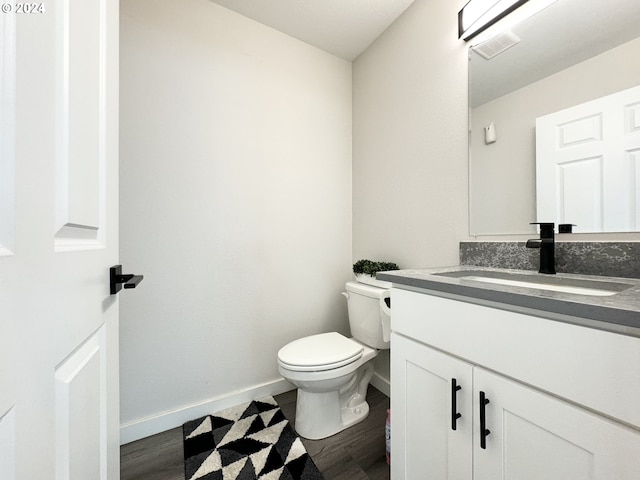 bathroom featuring vanity, toilet, and hardwood / wood-style floors