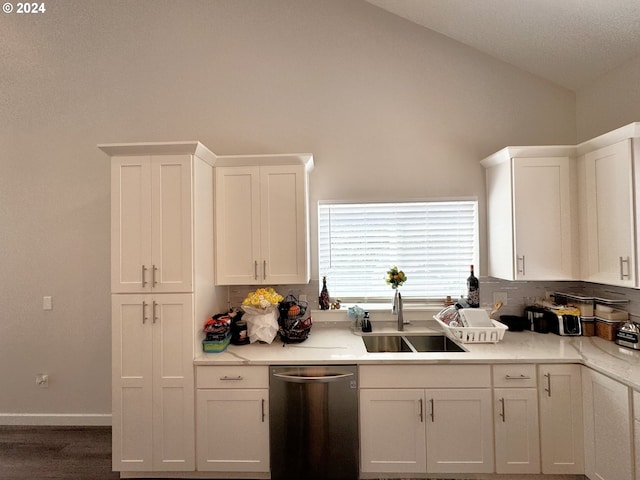 kitchen featuring dishwasher, lofted ceiling, white cabinetry, dark hardwood / wood-style flooring, and sink