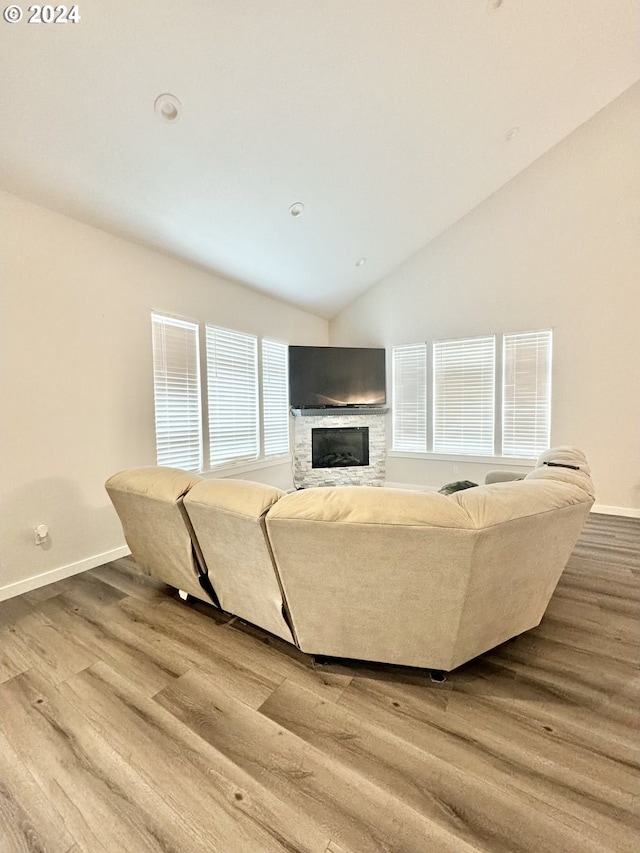 living room featuring a fireplace, wood-type flooring, and lofted ceiling