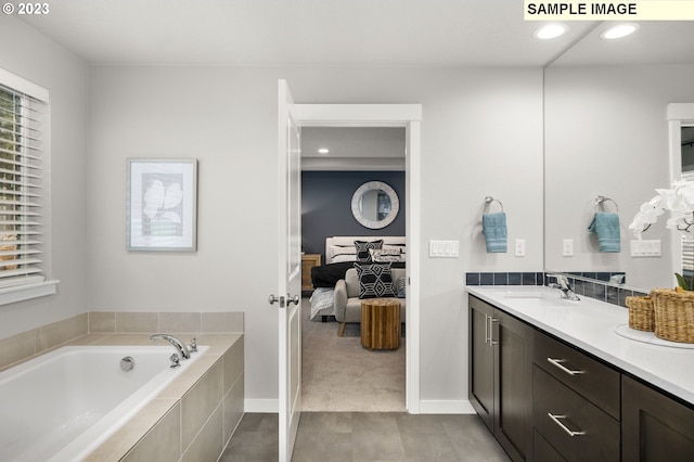 bathroom with vanity and a relaxing tiled tub