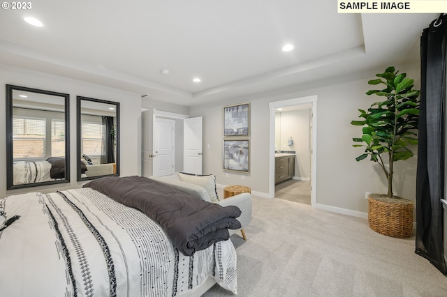 carpeted bedroom featuring ensuite bathroom and a tray ceiling