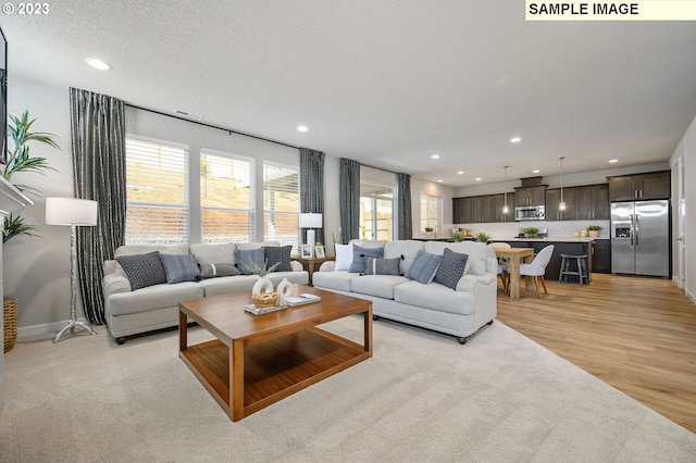 living room featuring a textured ceiling and light wood-type flooring