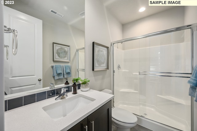 bathroom with toilet, an enclosed shower, and vanity