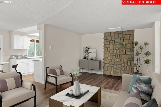 living room featuring dark hardwood / wood-style flooring, a textured ceiling, and sink