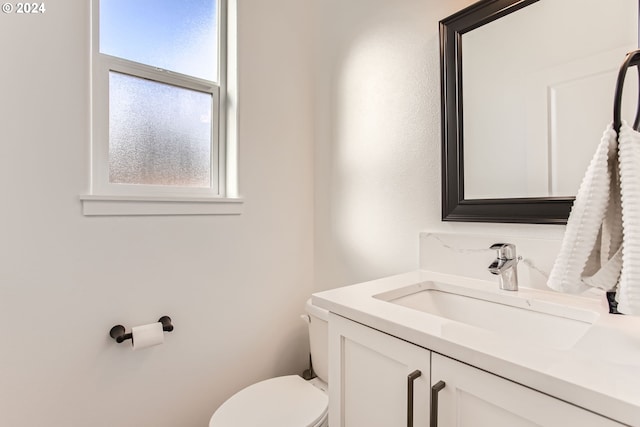 bathroom with vanity, a wealth of natural light, and toilet