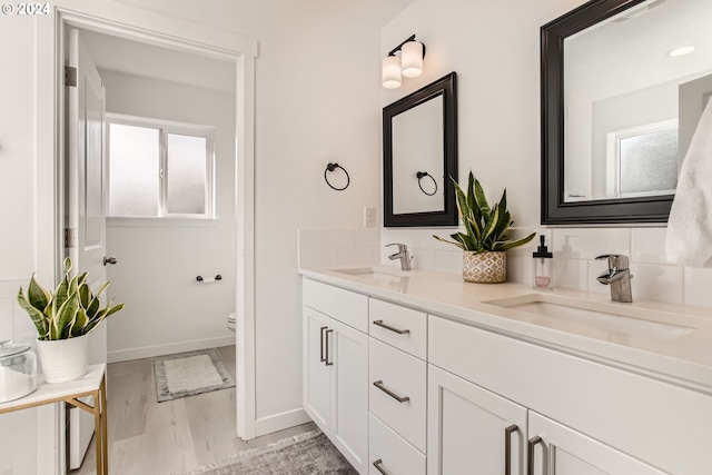 bathroom with vanity, hardwood / wood-style floors, decorative backsplash, and toilet