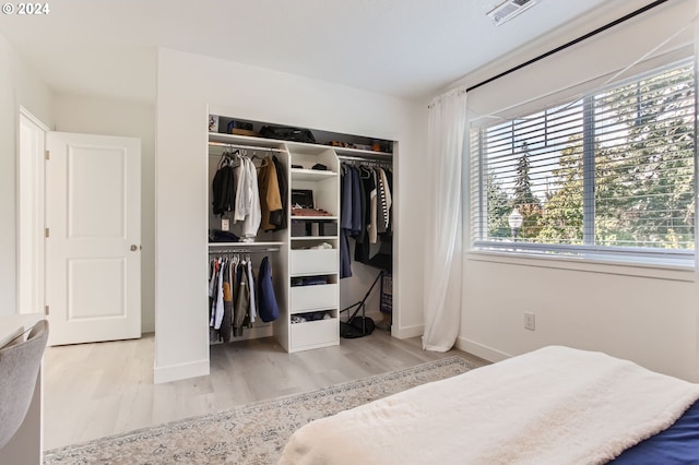 bedroom with light hardwood / wood-style floors and a closet