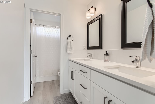 bathroom featuring vanity, tasteful backsplash, wood-type flooring, a shower with curtain, and toilet