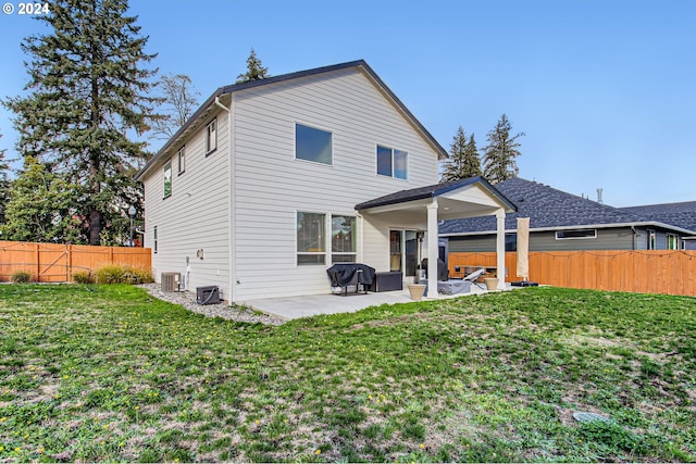 rear view of house with a yard, a patio area, and central air condition unit