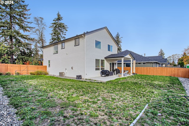 rear view of house with a yard, central AC unit, and a patio