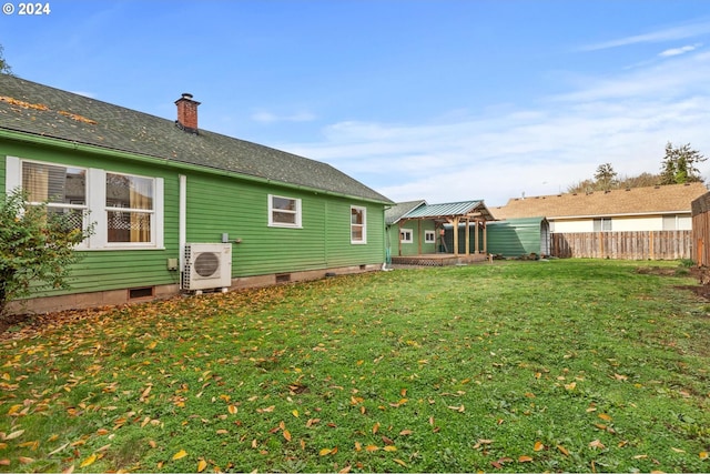 back of property featuring ac unit and a yard