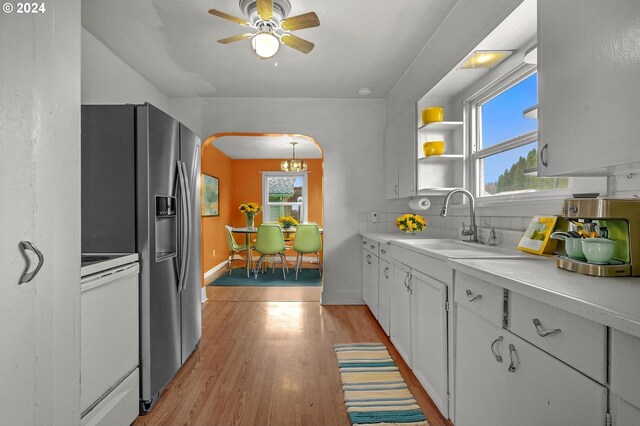 kitchen with white cabinets, sink, white stove, and a wealth of natural light