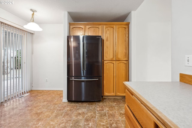 kitchen with hanging light fixtures and stainless steel fridge