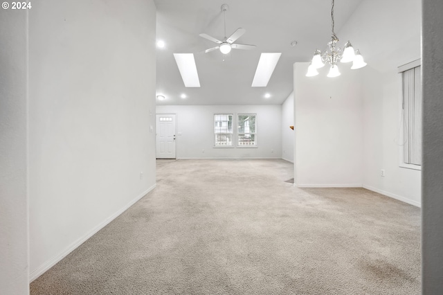 carpeted spare room featuring ceiling fan with notable chandelier and high vaulted ceiling