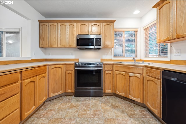 kitchen featuring sink, range with electric cooktop, and black dishwasher