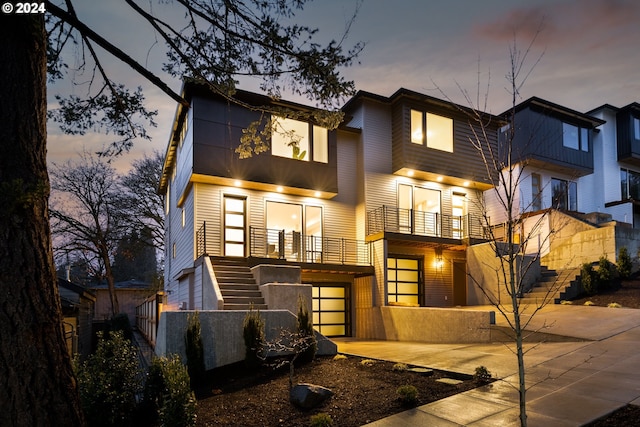 contemporary house featuring a garage and a balcony