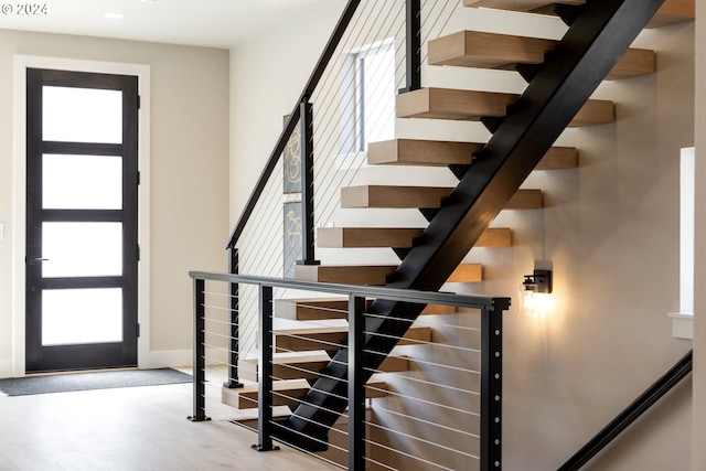 staircase featuring a wealth of natural light and hardwood / wood-style flooring