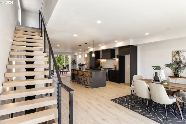 dining space with sink and light hardwood / wood-style flooring