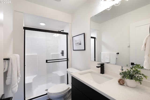 bathroom with a shower with door, toilet, and oversized vanity