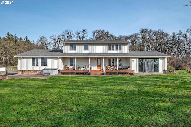 rear view of house featuring a yard, a hot tub, and a wooden deck