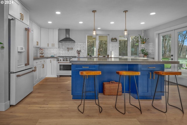33020 S Dickey Prairie Rd, Molalla, OR 97038 - kitchen with high quality appliances, wall chimney exhaust hood, dark countertops, decorative backsplash, and white cabinets