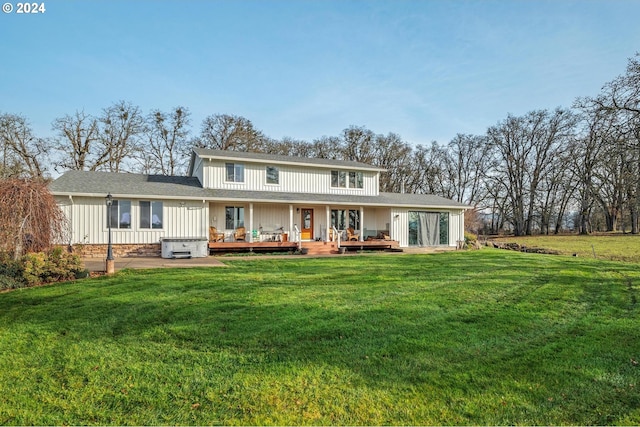 rear view of property featuring a wooden deck, a patio area, and a yard