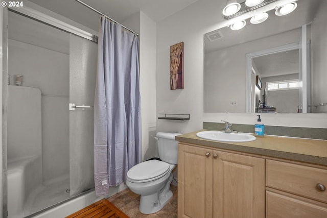 bathroom with walk in shower, tile patterned flooring, vanity, and toilet