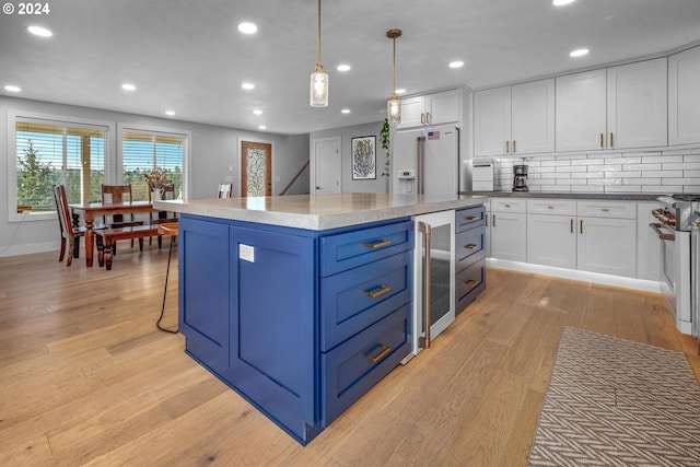 kitchen featuring decorative light fixtures, light wood-type flooring, white cabinetry, and high end white refrigerator