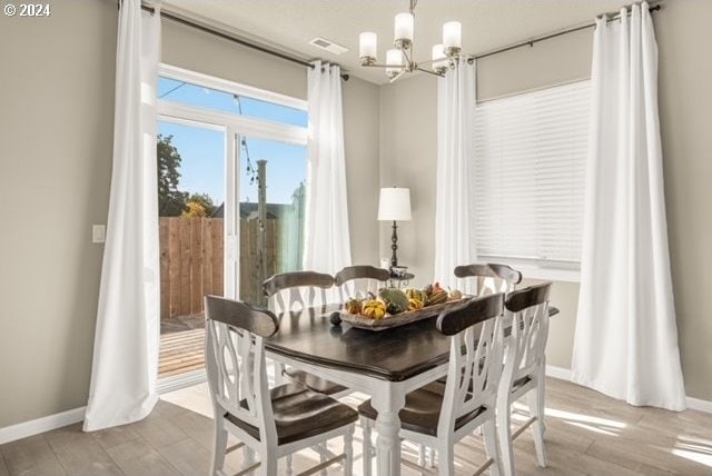 dining room featuring an inviting chandelier and light hardwood / wood-style flooring