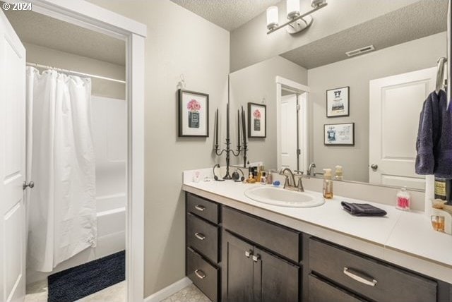 bathroom featuring a textured ceiling, vanity, and shower / tub combo with curtain