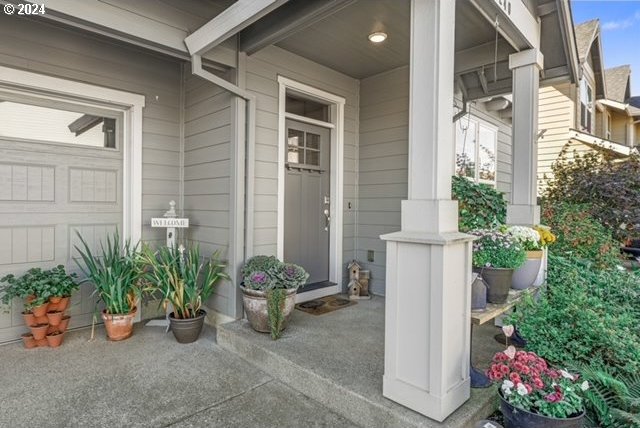 view of exterior entry with covered porch and a garage