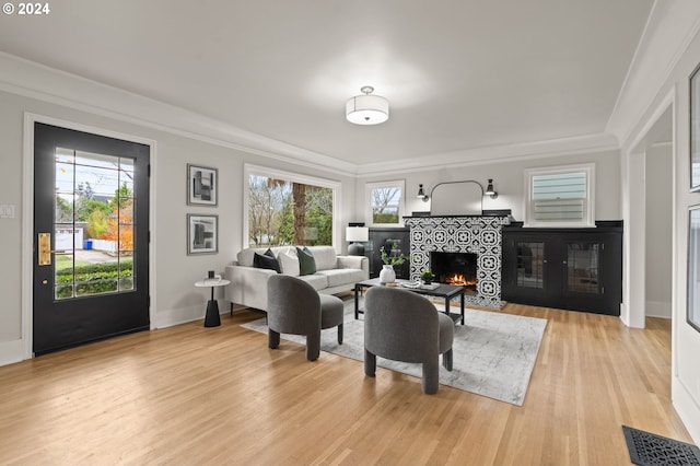 living room with a wealth of natural light, a fireplace, and light wood-type flooring