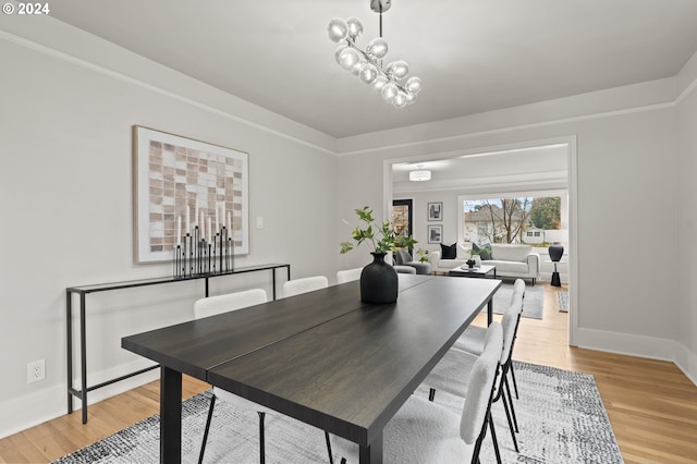 dining space featuring an inviting chandelier and light hardwood / wood-style flooring