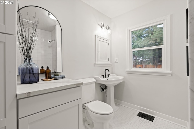 bathroom featuring tiled shower, tile patterned floors, and toilet