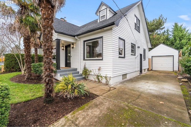 view of front of house featuring a garage and an outbuilding